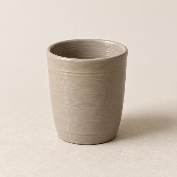 An unglazed studio cup at the trimmed stage